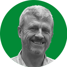 An image of Foundation CEO Duncan Macintosh in black and white, on a dark green background.
