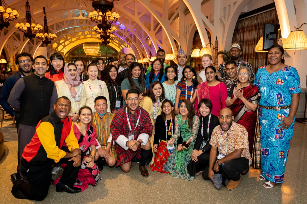 The APNIC 54 fellows at an event in Singapore in 2022. They are at an evening function in a ballroom.