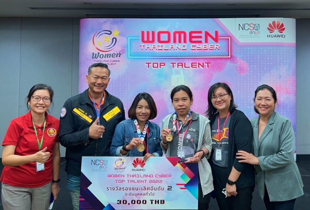 A group of Switch! participants hold a novelty cheque in front of a Women Thailand Cyber Top Talent banner.