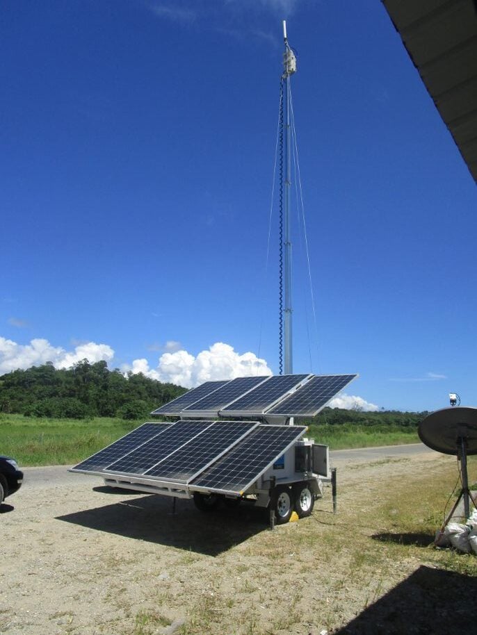 The picture shows an antenna set up on wheels with a large solar panel rack.