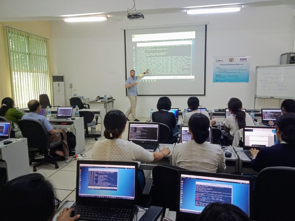 An APNIC trainer stands at the front of the class during the workshop.
