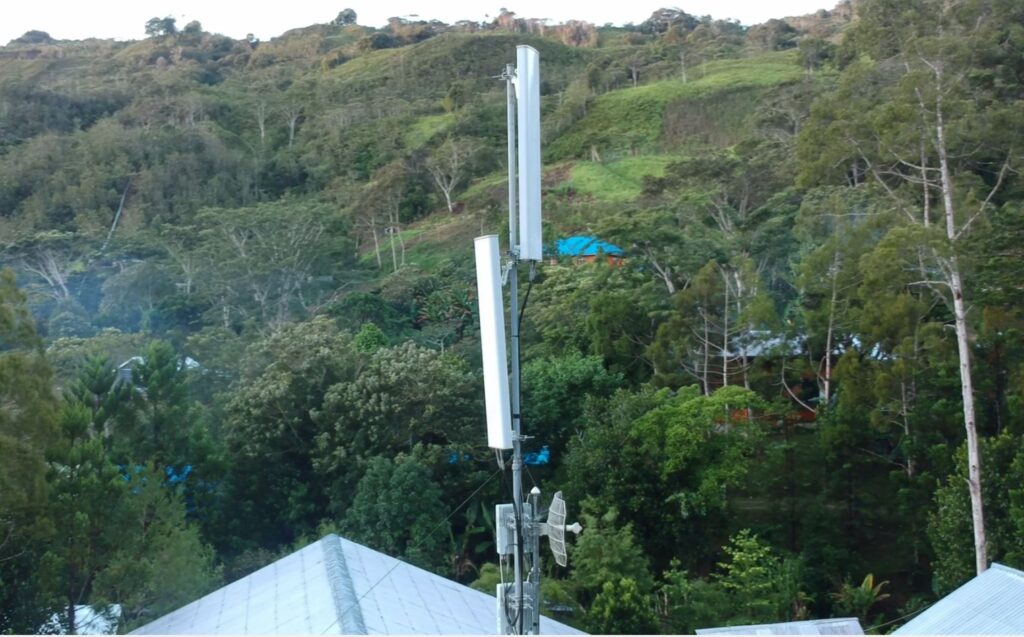 The picture shows an antenna amid lush mountains