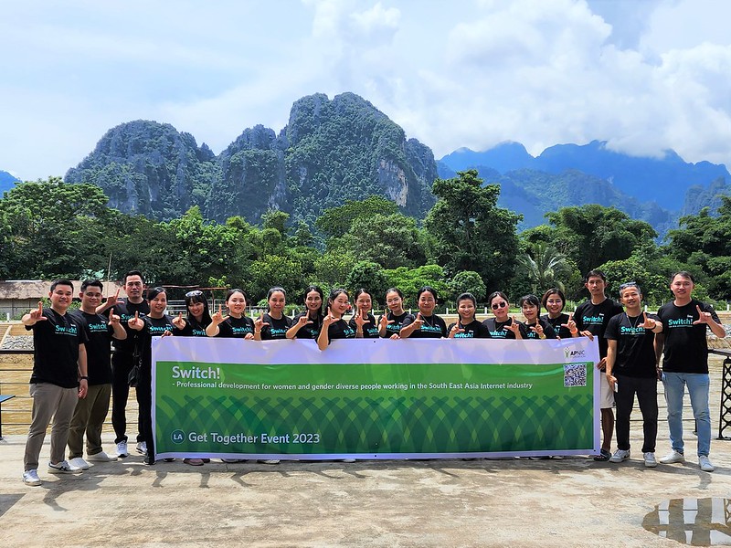 A group of project participants holding a Switch! banner with mountains in the background.