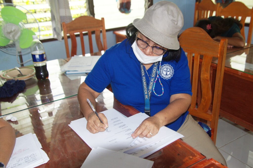 A woman signing a document as part of the project.