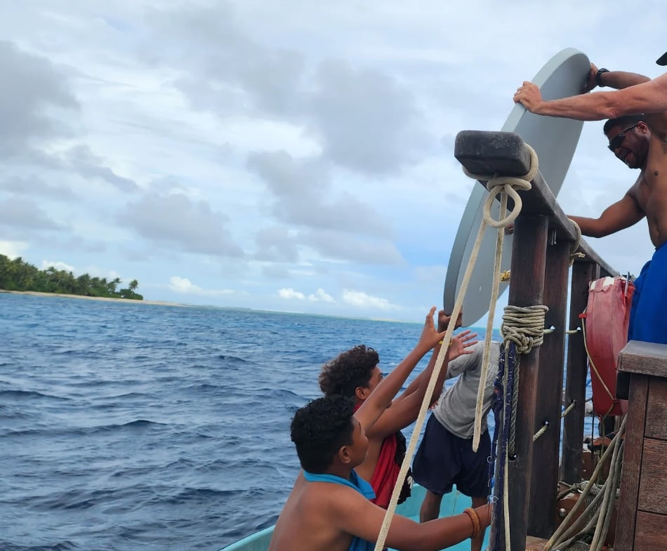 Team members use a traditional canoe to offload satellite gear onto islands, to set up connectivity in locations where some residents previously hadn't even had phone connections.